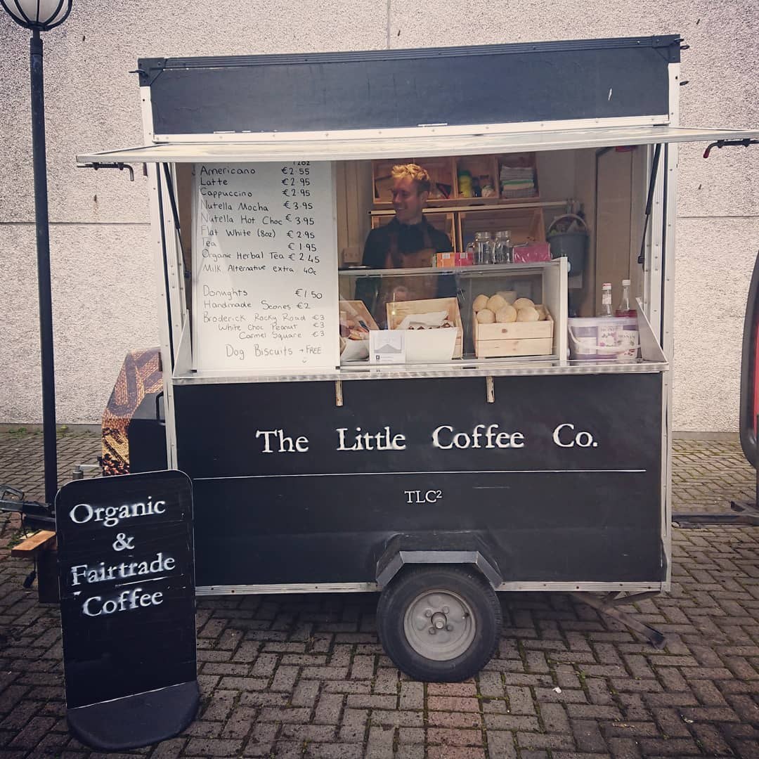 The serving hatch of The Little Coffee Co trailer, with an Organic & Fairtrade Coffee board and homemade scones
