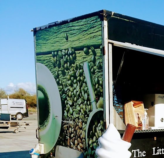 Coffee-bean wrap on the side of The Little Coffee Co trailer, with the serving hatch open